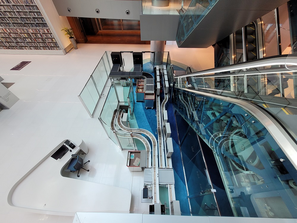 Inside Dubai's library. The image shows a Bibliotheca product,flexAMH and bulkSeparator, which streamlines returns in the library system by allowing users to drop off items through an induction point. The system then separates, checks in, sets security, and sorts all the items ready to be moved to their destination. The transportation system ensures the easy transportation of materials to the correct location across multiple floors.​