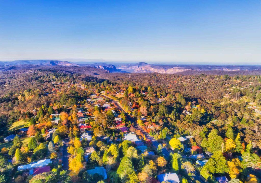 Aerial view of Blackheath, home to one of the six branches of the Blue Mountains Library System, surrounded by forested mountains and colorful homes.