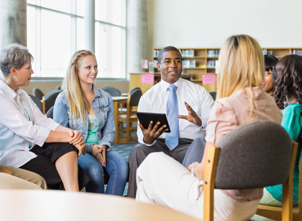 A group of people meeting in their library