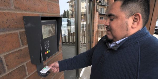 A patron scanning a library card at an access control panel, using Scott County Library’s extended access program, which saw a 120% increase in new users.
