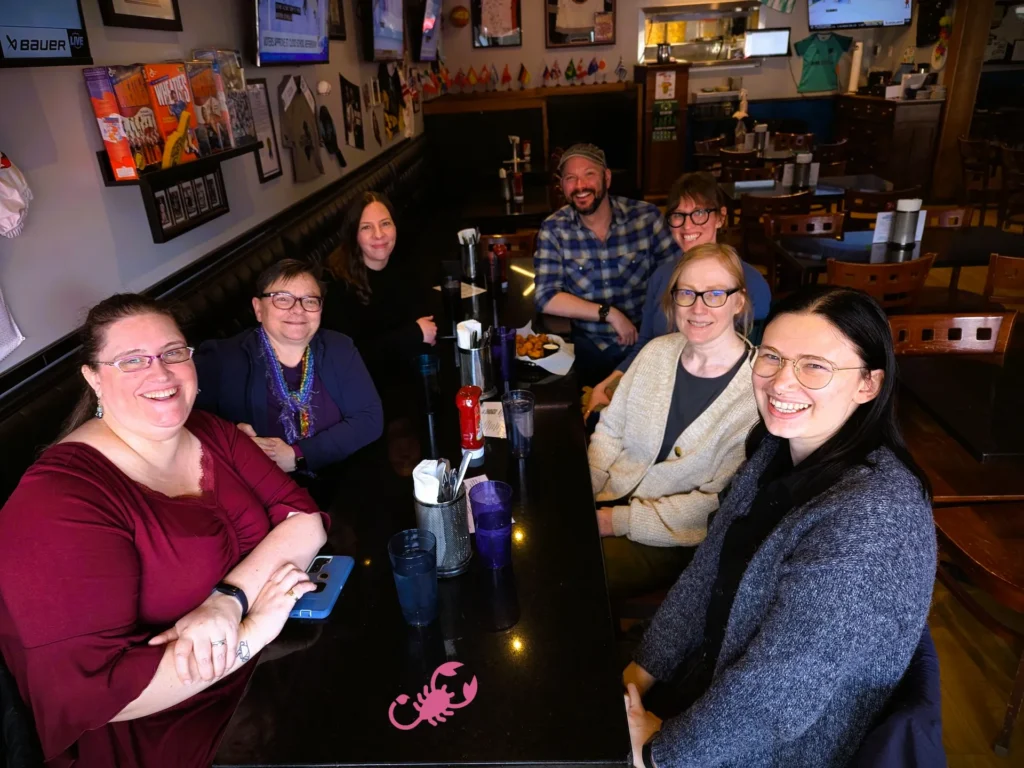 The Lindell Library staff at Augsburg University gathered together at a local restaurant, smiling and celebrating collaboration and innovation in library service.