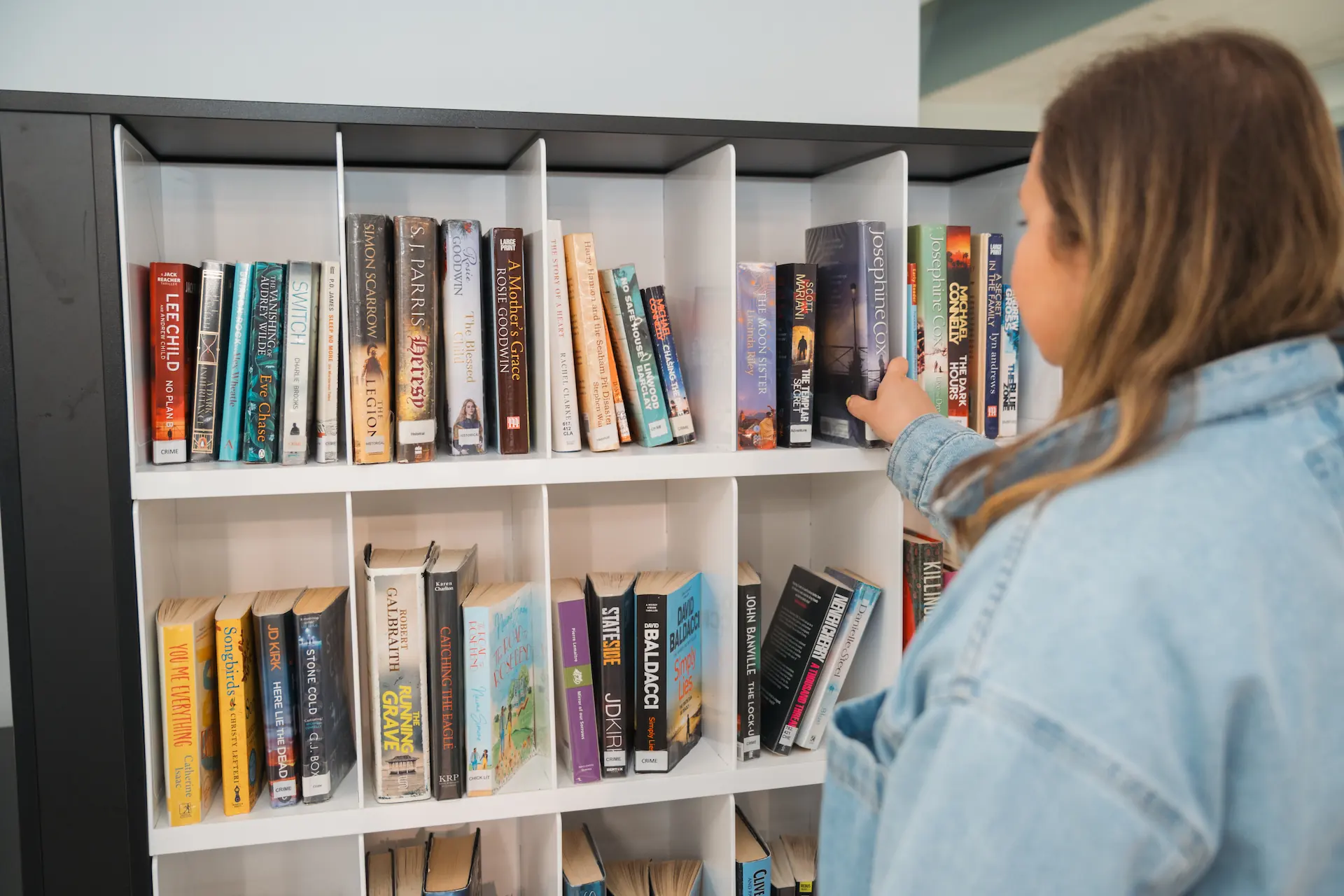 Library visitor using Bibliotheca smartShelf Borrow at Sunderland Libraries to return and borrow books quickly and intuitively.